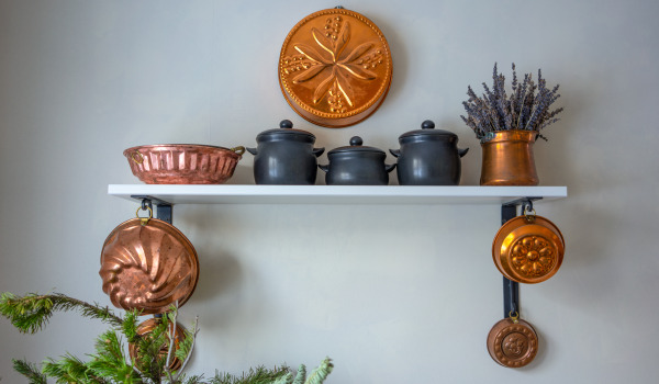 What decoration on an empty kitchen wall will improve its appearance?